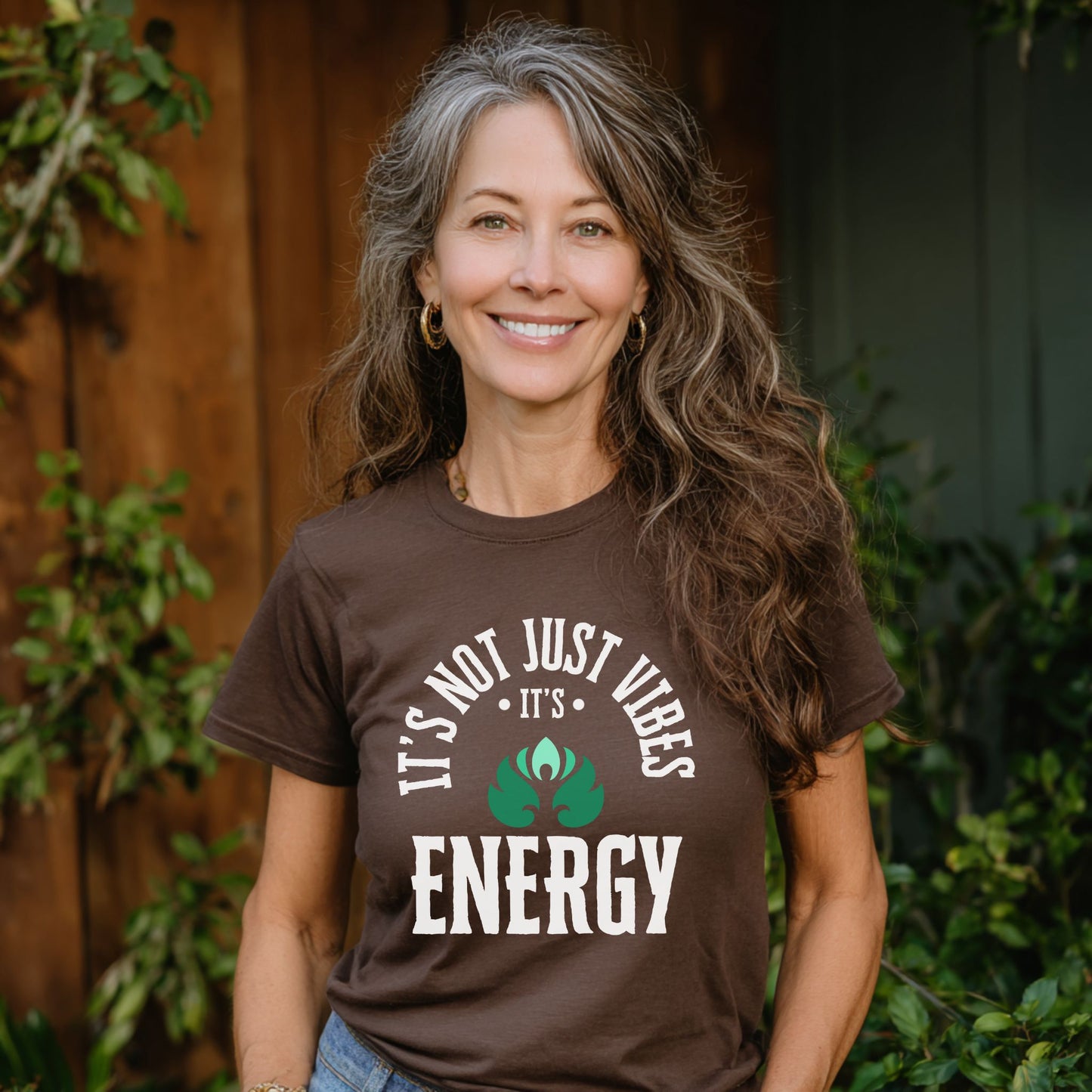 Woman wearing a brown t-shirt with a motivational energy quote outdoors – Lunar Lightwear conscious clothing