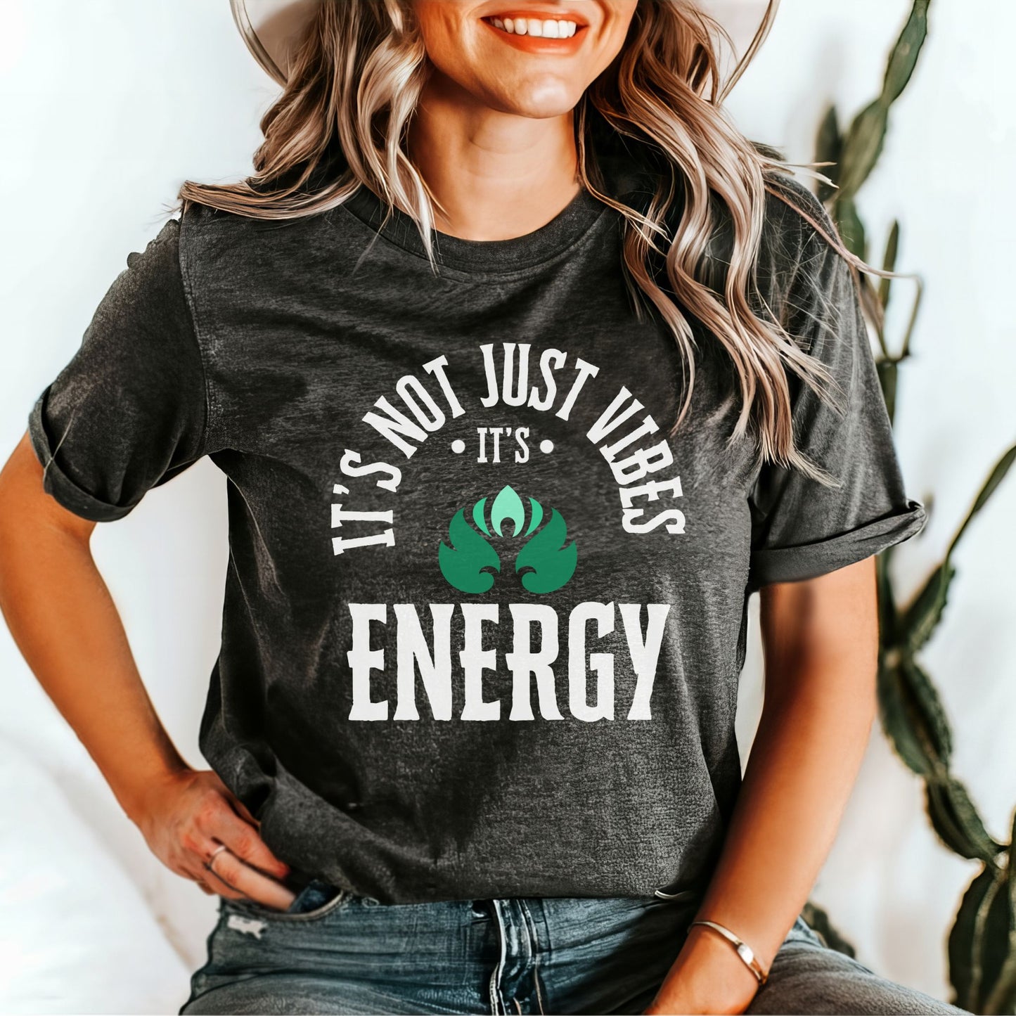 Woman wearing a dark grey heather t-shirt with 'It's not just vibes, it's energy' text and a green graphic – Lunar Lightwear conscious clothing