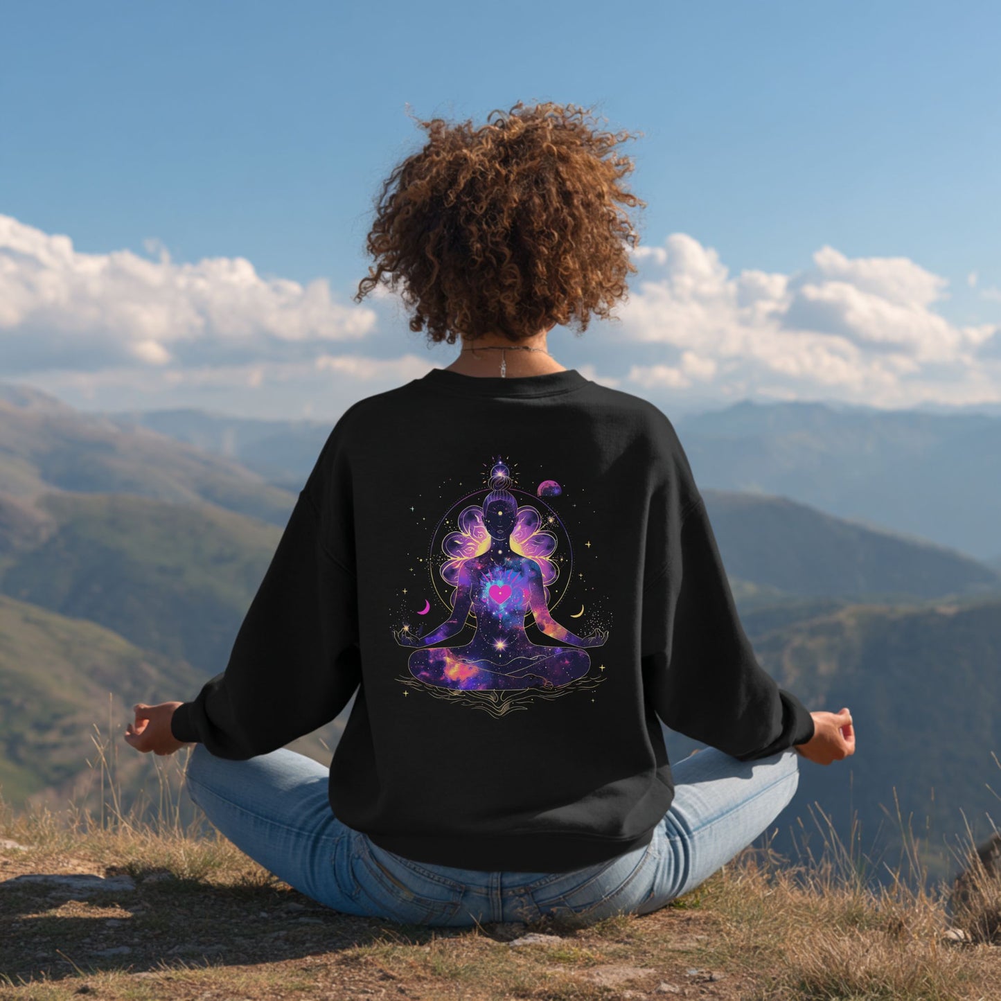 Woman model meditating on a mountain top wearing sweatshirt featuring meditating woman silhouette, cosmic stars, moons, and floral details, a spiritual design – Lunar Lightwear conscious clothing