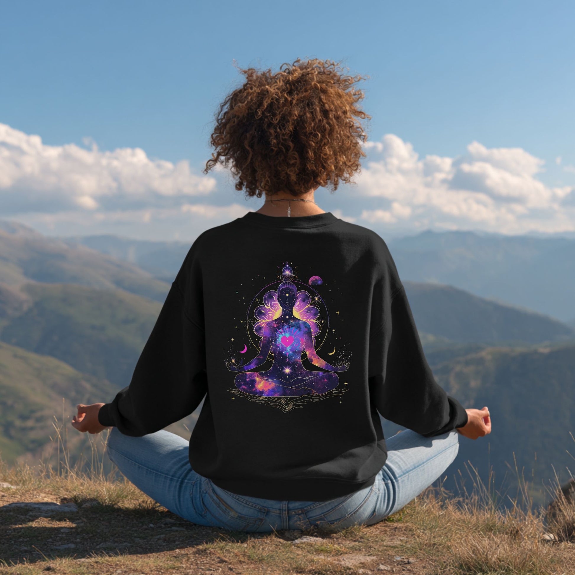 Woman model meditating on a mountain top wearing sweatshirt featuring meditating woman silhouette, cosmic stars, moons, and floral details, a spiritual design – Lunar Lightwear conscious clothing