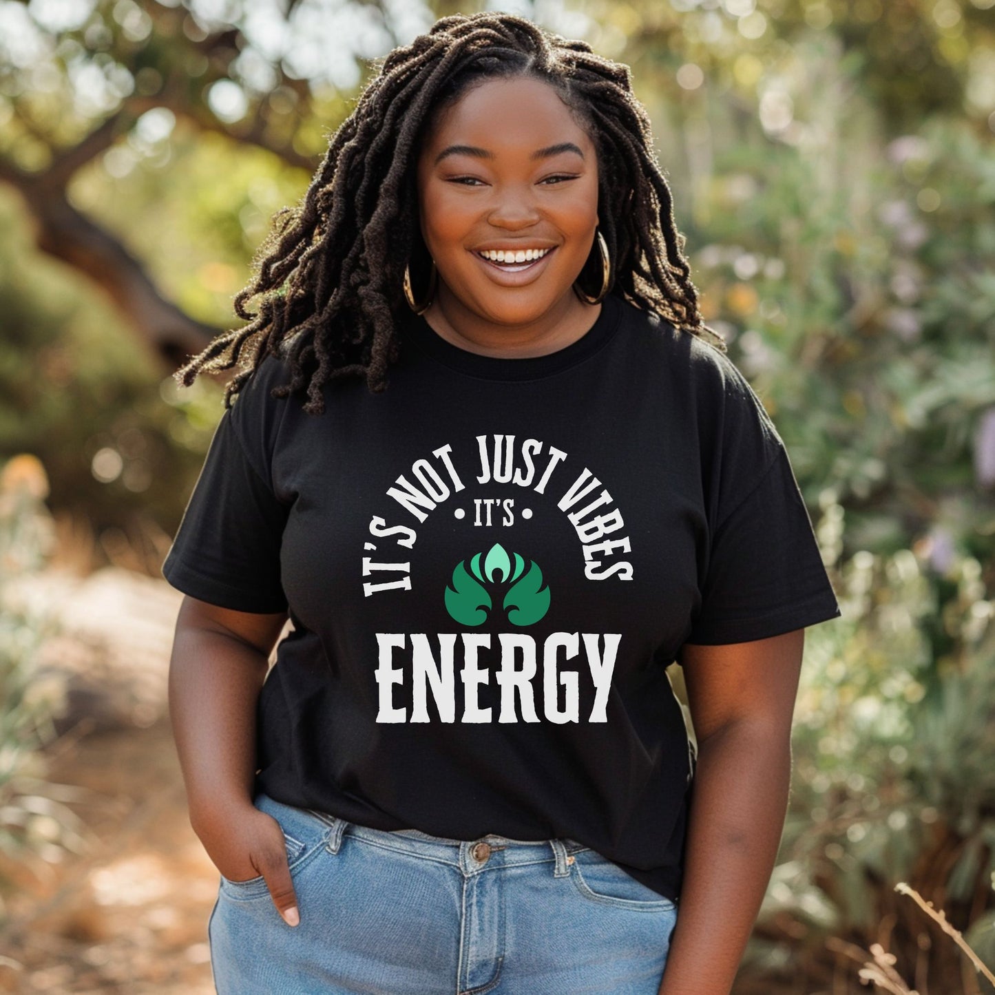 Person wearing a black t-shirt with 'It's Not Just Vibes, It's Energy' text and design outdoors – spiritual and cosmic apparel by Lunar Lightwear