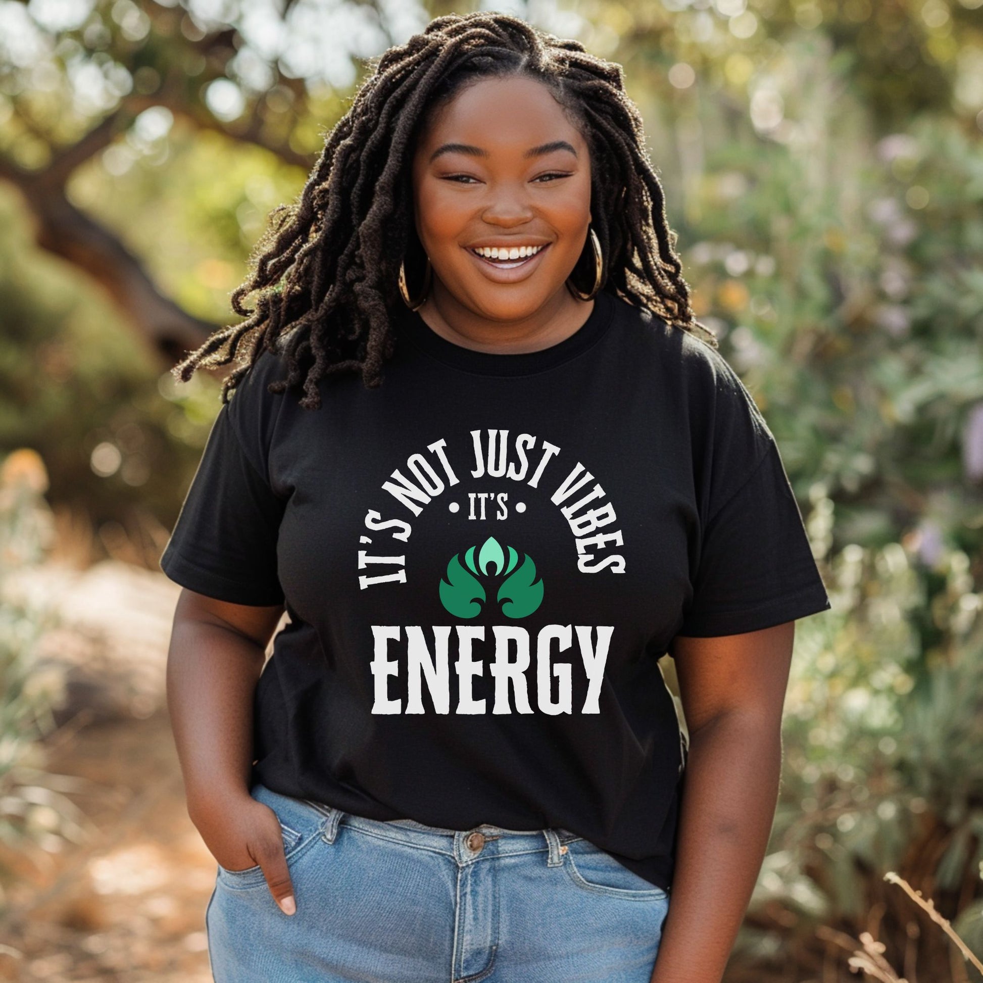 Person wearing a black t-shirt with 'It's Not Just Vibes, It's Energy' text and design outdoors – spiritual and cosmic apparel by Lunar Lightwear