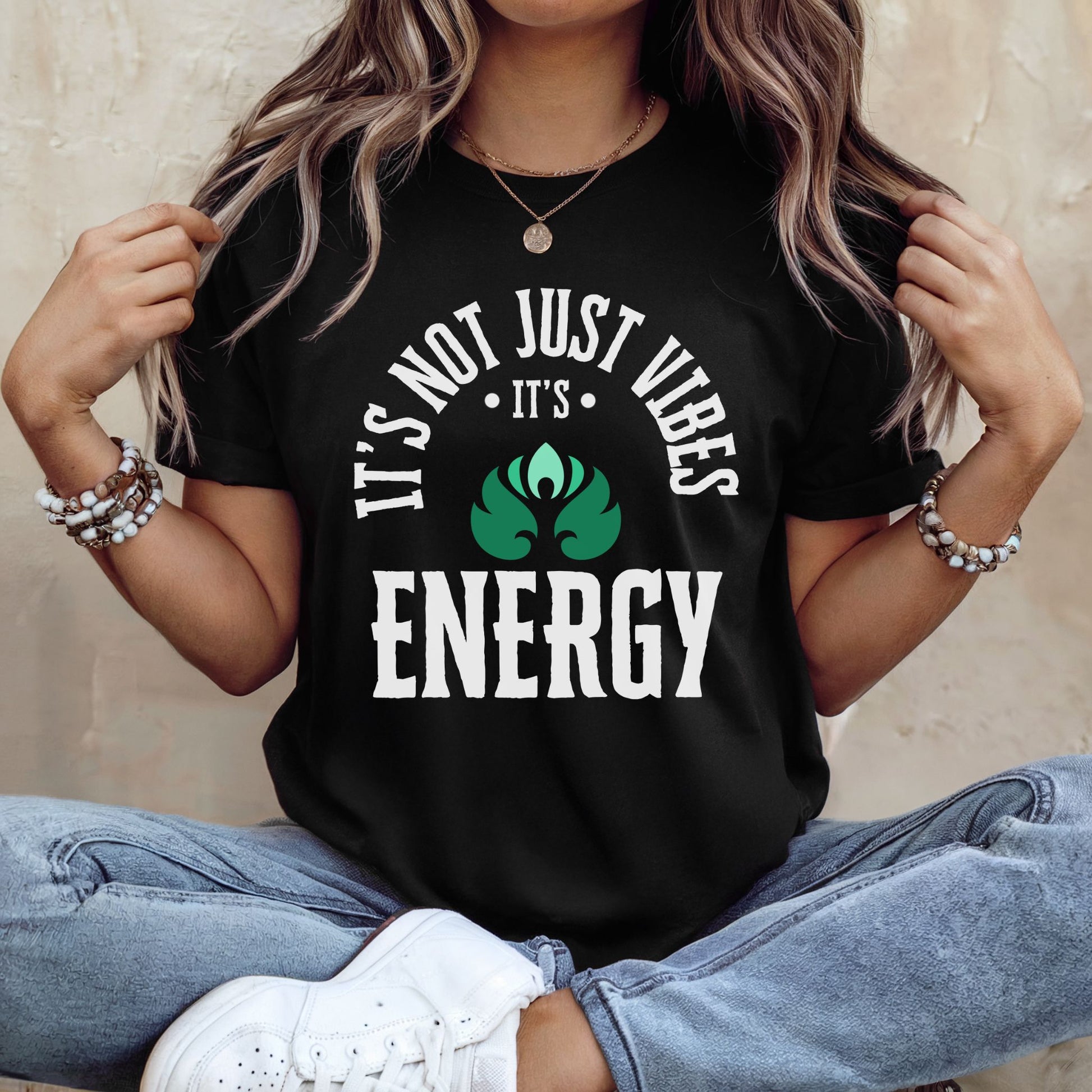 Person wearing a black t-shirt with 'It's not just vibes, it's energy' text and green leaf graphic – spiritual and cosmic apparel by Lunar Lightwear