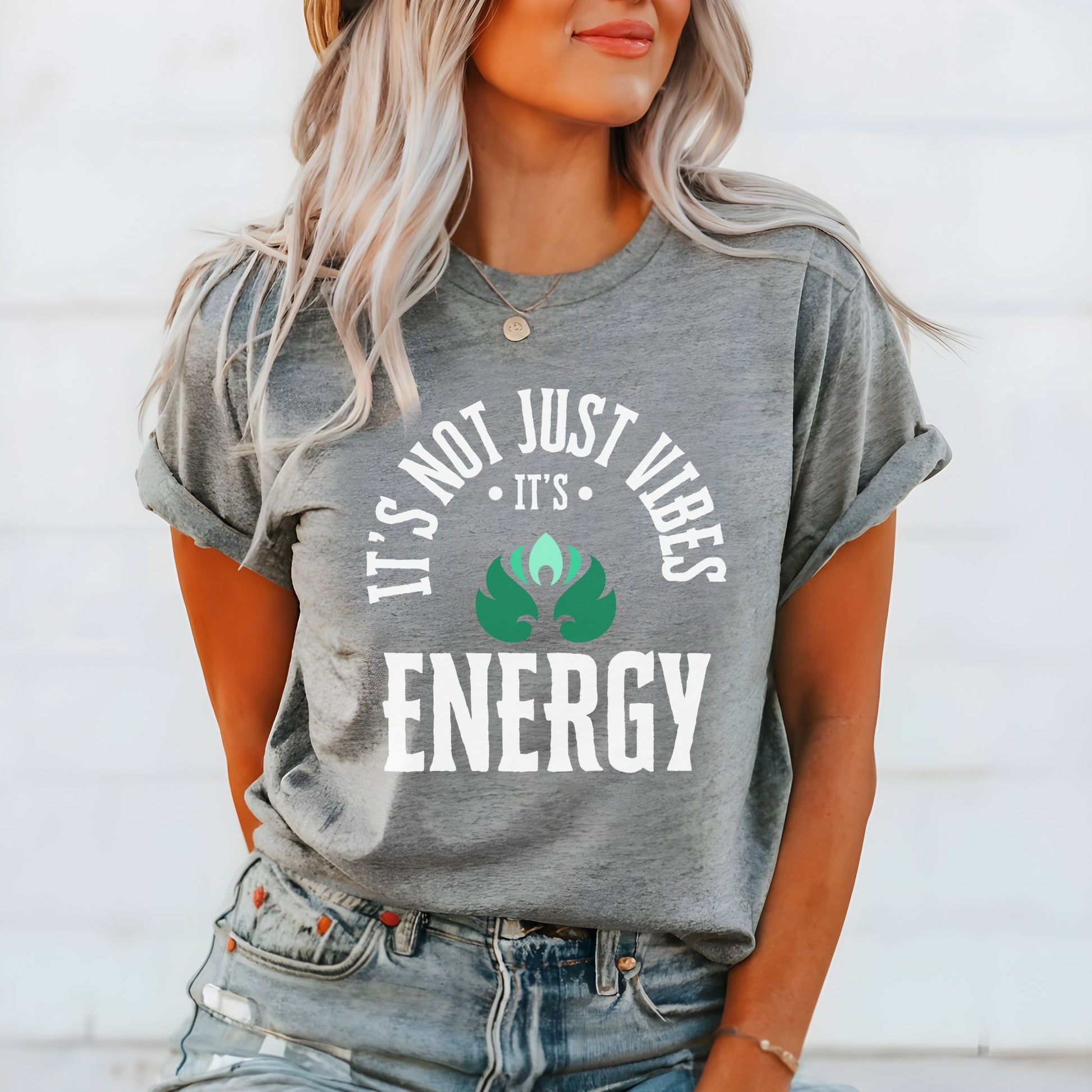 Person wearing a gray t-shirt with a motivational quote and graphic design.