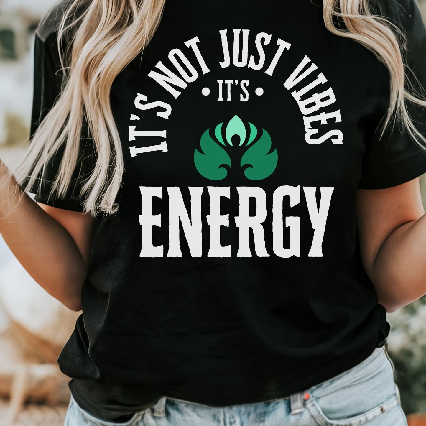 Person wearing a black t-shirt with 'It's not just vibes, it's energy' text and green leaf graphic – spiritual and cosmic apparel by Lunar Lightwear