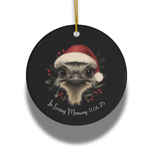Round black ornament with an ostrich wearing a Santa hat and holly red berries